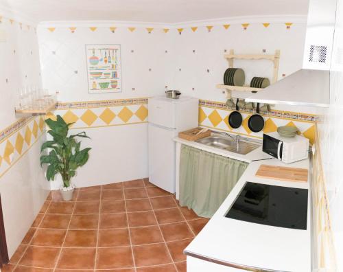 Una cocina con gabinetes blancos y encimera. en BN Casa Cecilia SPA, en Benaocaz
