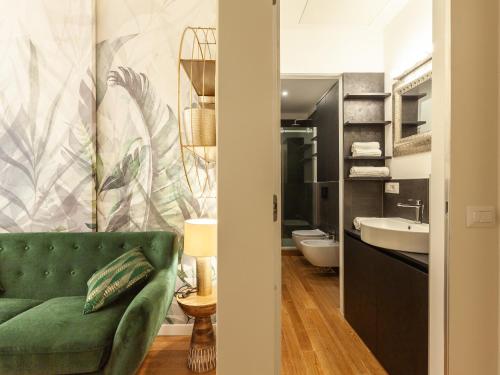a bathroom with a green couch and a sink at easyhomes - Vincenzo Monti in Milan