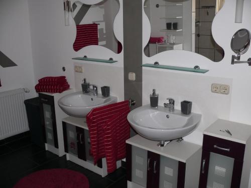 uma casa de banho com dois lavatórios e dois espelhos em Ferienwohnung Natur-Pur em Ehrenberg