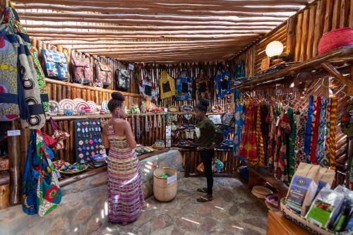 a woman standing in front of a shop in a market at Bunyonyi Overland Resort in Kabale