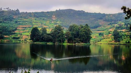a person is water skiing on a lake at Bunyonyi Overland Resort in Kabale