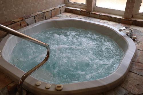 a jacuzzi tub with water in it at 白樺湖ペンションロック in Chino