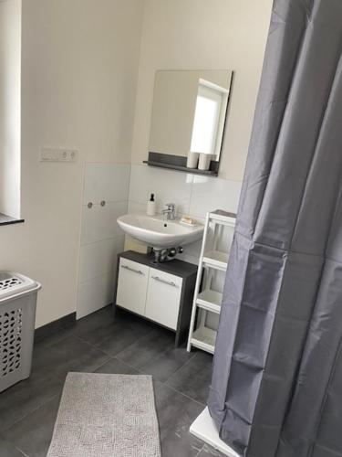 y baño con lavabo y espejo. en 3 Mehrbettzimmer, Küche, Bad für Arbeiter und Monteure, en Gau-Weinheim