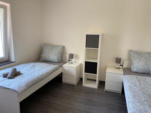 a bedroom with two beds and two night stands at 3 Mehrbettzimmer, Küche, Bad für Arbeiter und Monteure in Gau-Weinheim in Gau-Weinheim