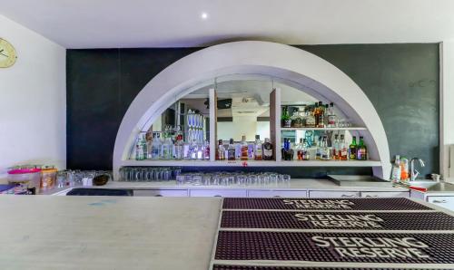 a bar with an archway in a room with drinks at Treebo Concerto Residentia in Durgāpur