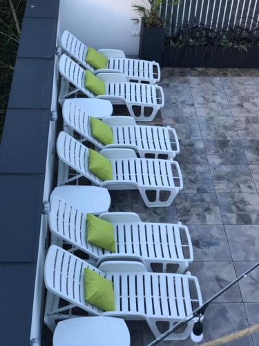 una fila de sillas blancas con almohadas verdes en Hotel Imperium, en Chełmża