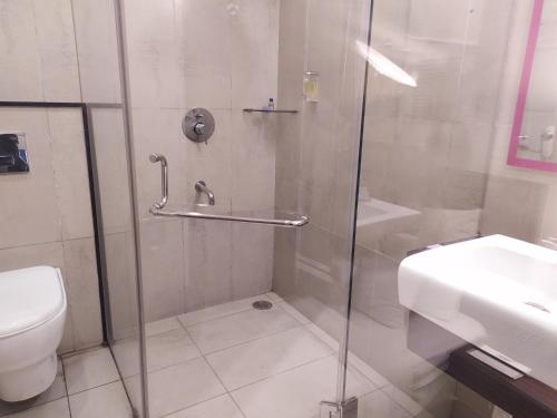 a bathroom with a shower with a toilet and a sink at The Theme, Jaipur in Jaipur