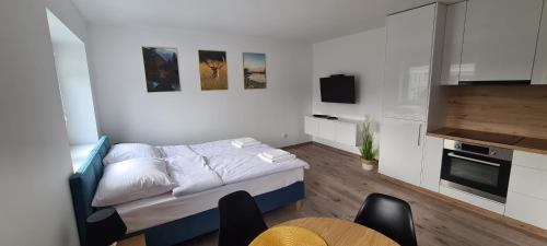 a small room with a bed and a table and chairs at Apartamenty Happy in Lębork