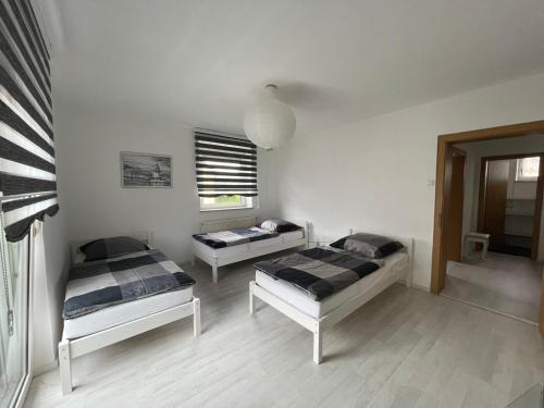 - une chambre avec 2 lits et une fenêtre dans l'établissement Guntia Apartment mit großem Garten, à Guntzbourg