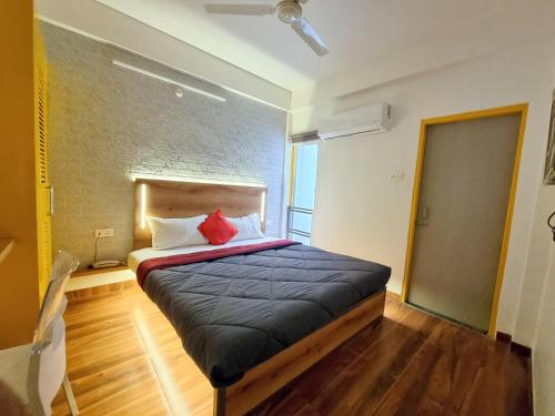 a bedroom with a large bed with two red pillows at Stayinn Nest in Bhopal