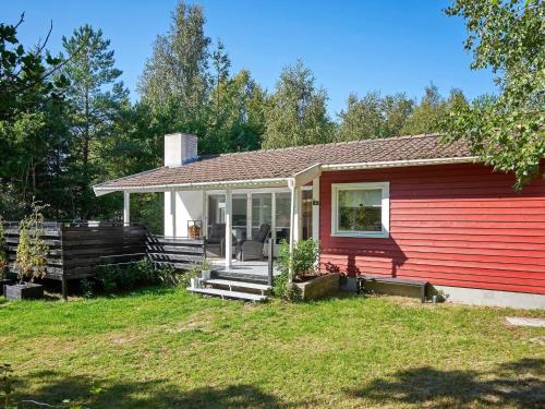 a red and white house with a porch at 4 person holiday home in Aakirkeby in Vester Sømarken