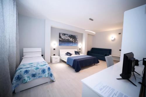 ein Schlafzimmer mit einem Bett, einem Sofa und einem TV in der Unterkunft IsolaDino b&b sweet home in Praia a Mare