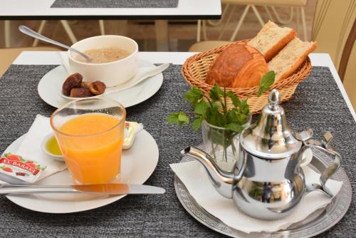 uma mesa com pequeno-almoço de sumo de laranja e pão em Hotel Residence Imiplage em Agadir