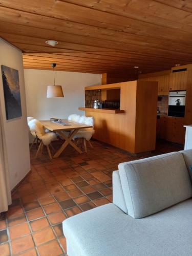 een woonkamer met een tafel en een keuken bij Appartement Aareschlucht- Grandiose Aussicht für 2-6 pers. in Meiringen