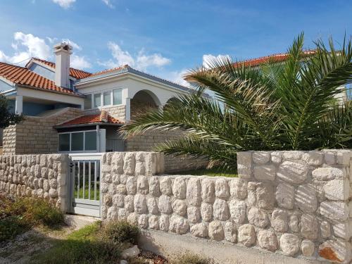 une maison avec un mur en pierre et une clôture dans l'établissement Holiday home Ankica, à Ražanac