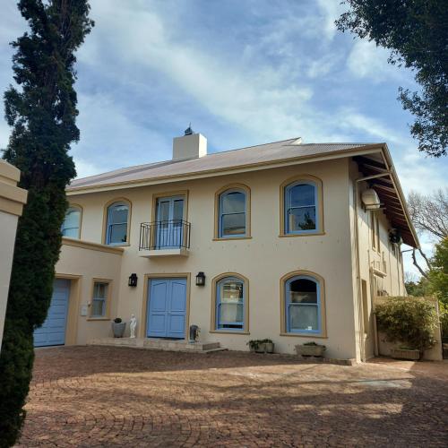 a large white house with a roof at Rustic Manor Guest House in Tokai