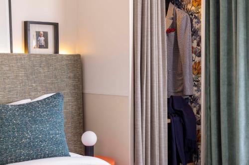 een slaapkamer met een bed, een gordijn en een spiegel bij Hotel Dadou Paris in Parijs