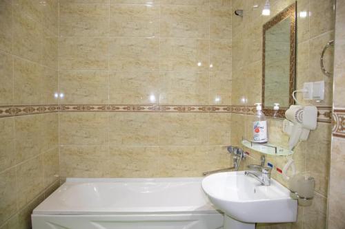 a bathroom with a white tub and a sink at Euro Asia Hotel in Samarkand