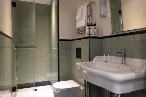 La salle de bains est pourvue d'un lavabo, d'une douche et de toilettes. dans l'établissement Hotel Dadou Paris, à Paris