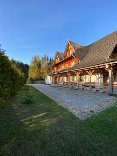 a large wooden building with a pathway in front of it at Willa Arnika in Lutowiska