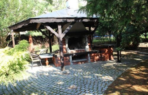 a pavilion with a table and a bench in a park at GARDENIA in Jelenia Góra