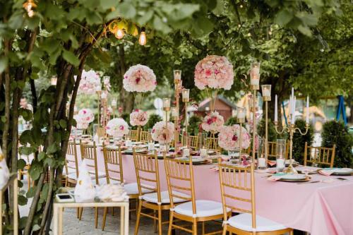 a long table with chairs and pink flowers at Kod Brke in Veliko Gradište