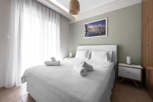 a bedroom with a white bed with towels on it at Melba's Residence Polihrono by Luxlikehome in Polychrono