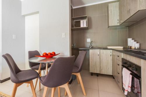 een keuken met een tafel met stoelen en een fruitschaal erop bij Bedfordview Haven in Johannesburg
