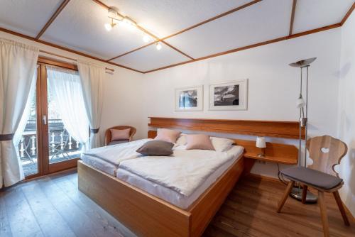 a bedroom with a bed and a desk and a window at Höhengasthaus Kolmenhof an der Donauquelle in Furtwangen