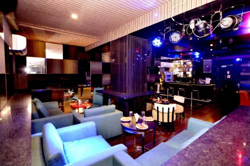 una sala de estar con sofás azules y un bar en The Theme, Jaipur, en Jaipur