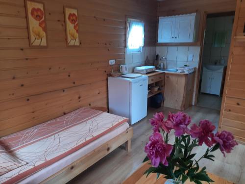 um quarto com uma cama e uma cozinha com um frigorífico em Pod Bocianim Gniazdem 691-363-701 em Bachlowa