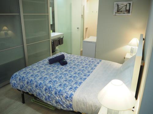 カレリャ・デ・パラフルジェリにあるAcogedor loft en Calella de Palafrugellのベッドルーム1室(青い毛布と鏡付きのベッド1台付)