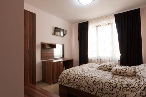 a bedroom with a bed and a window at Hotel Verona in Byala Ruse