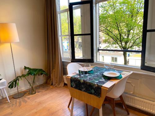 a dining room with a table and chairs and a window at The Canalview Retreat in Amsterdam