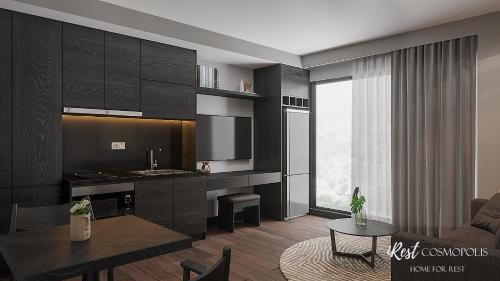 a kitchen and living room with black cabinets and a table at iRest COSMOPOLIS Vinh Yen in Yen