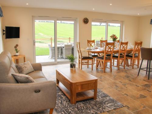 a living room with a couch and a table and chairs at Holly Lodge in Welshpool