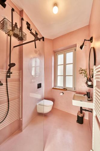 a pink bathroom with a toilet and a sink at Casa Carlazzo in Carlazzo