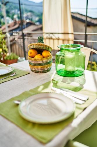 a table with a plate and a bowl of oranges at Casa Carlazzo in Carlazzo