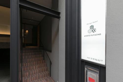 a staircase leading into a building with a sign on it at Design Hotel Kyoto Fuyacho in Kyoto