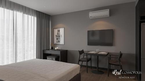 a bedroom with a bed and a desk and a tv at iRest COSMOPOLIS Vinh Yen in Yen