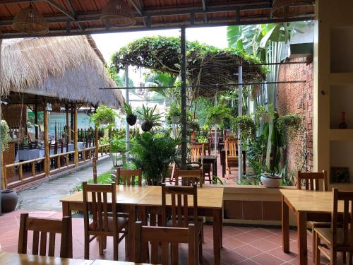 a restaurant with tables and chairs and a large window at Tropical Garden Phu Quoc in Phu Quoc
