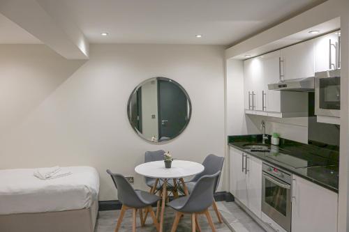 a small kitchen with a table and chairs in a room at Hyde Park Superior Apartments in London