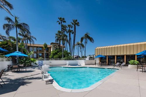 a pool with chairs and umbrellas in a resort at Wyndham Garden San Diego in San Diego