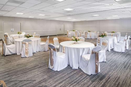 a room with white tables and chairs with flowers on them at Wyndham Garden San Diego in San Diego