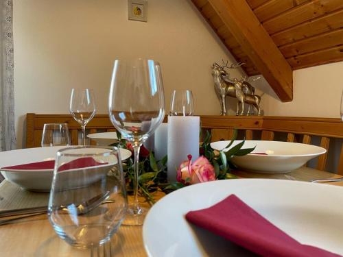 a table with wine glasses and plates on it at Ferienwohnungen Am Kirchberg in Neualbenreuth