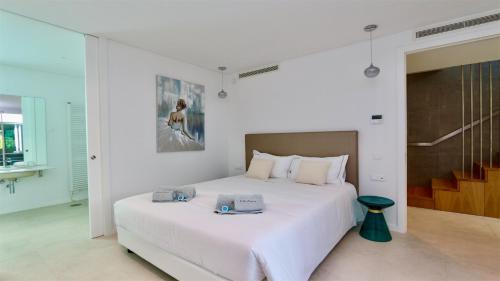 une chambre avec un grand lit blanc avec des serviettes dessus dans l'établissement Villa Terese-CleverDetails, Central Vilamoura, Sleeps 6, luxury, walking distance, à Vilamoura