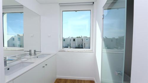 une salle de bain blanche avec deux lavabos et une fenêtre dans l'établissement Villa Terese-CleverDetails, Central Vilamoura, Sleeps 6, luxury, walking distance, à Vilamoura