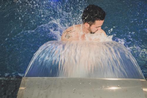a man in a bath tub in a pool of water at Gara Suites Golf & Spa in Playa de las Americas