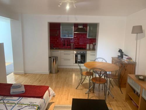 ロンドンにあるCozy 1 Bedroom Basement Flatの部屋にテーブルと椅子のあるキッチン