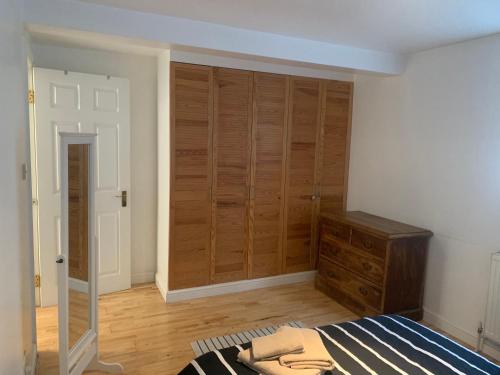 a bedroom with a bed and wooden closets at Cozy 1 Bedroom Basement Flat in London